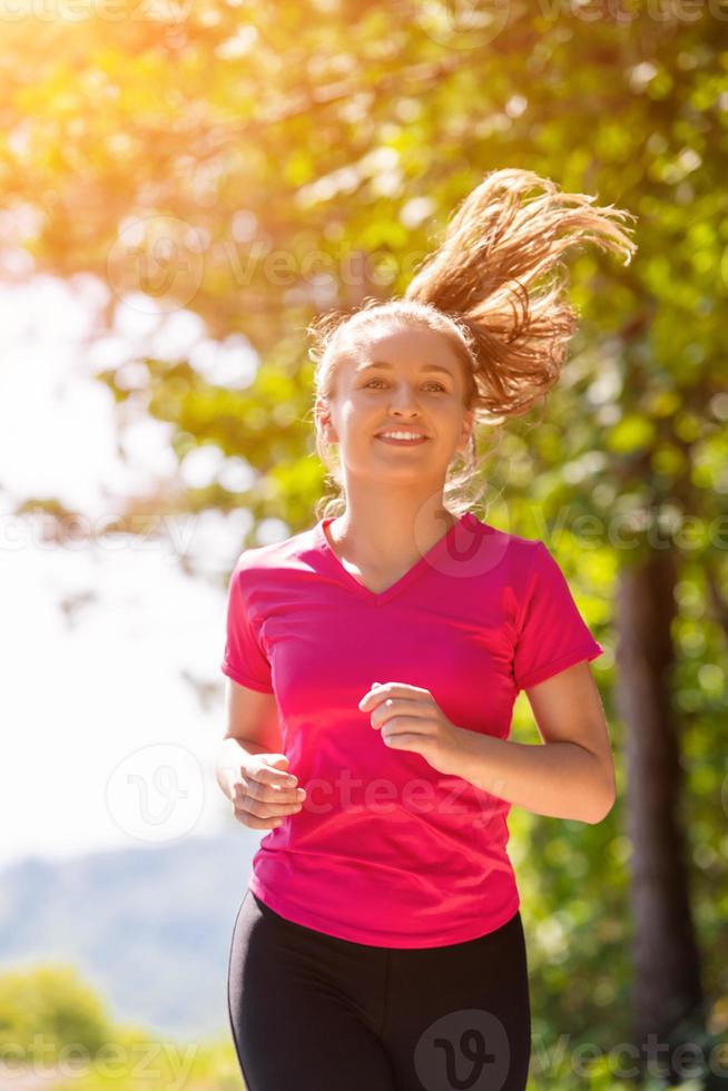 giovane donna jogging su soleggiato giorno a natura foto