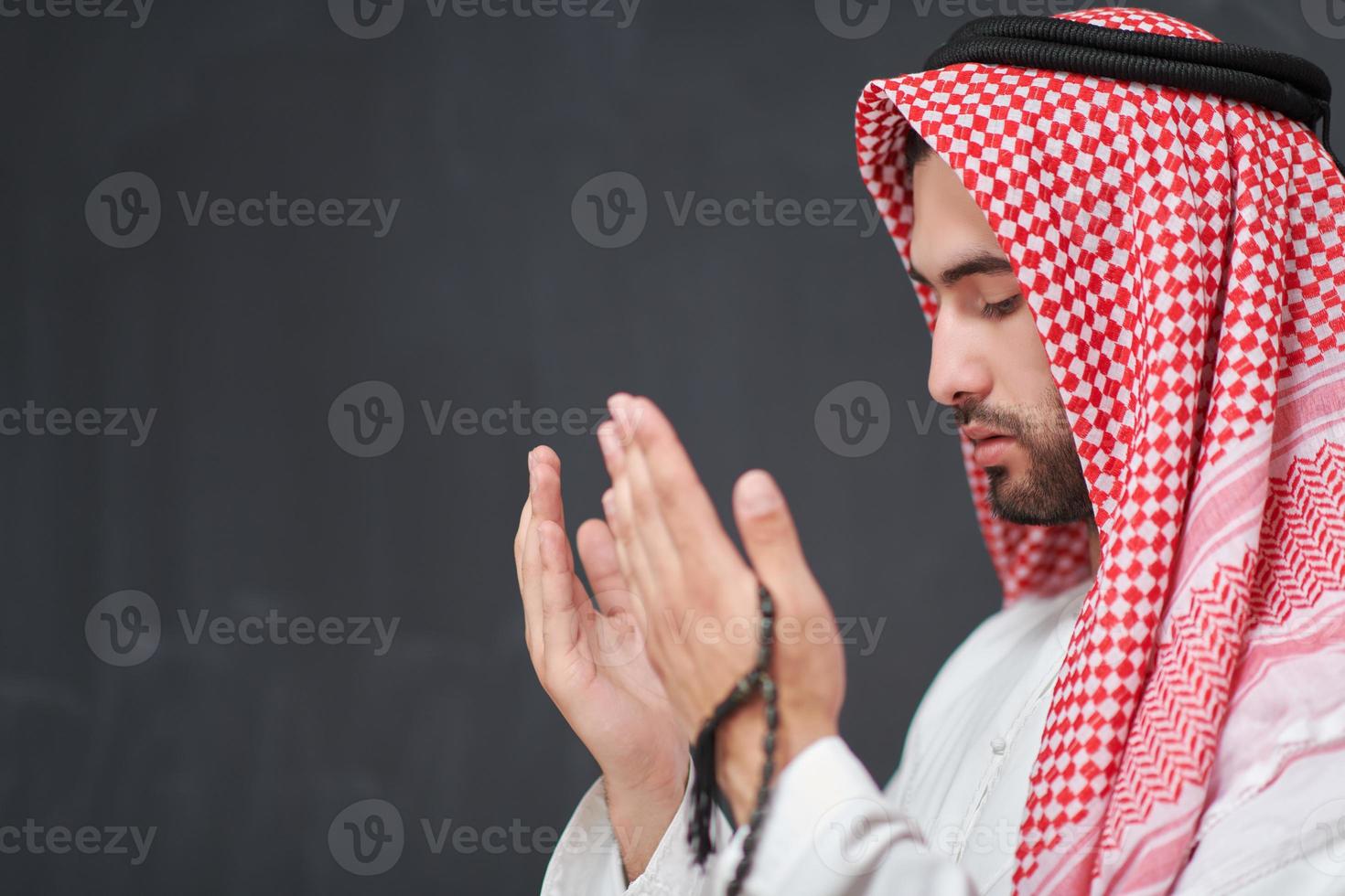 arabo uomo nel tradizionale Abiti preghiere per Dio o fabbricazione dua foto