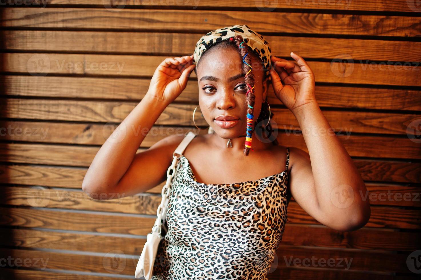 bello africano americano donna con dreadlocks nel leopardo attrezzatura a bar. bellissimo freddo alla moda nero giovane ragazza interno. foto