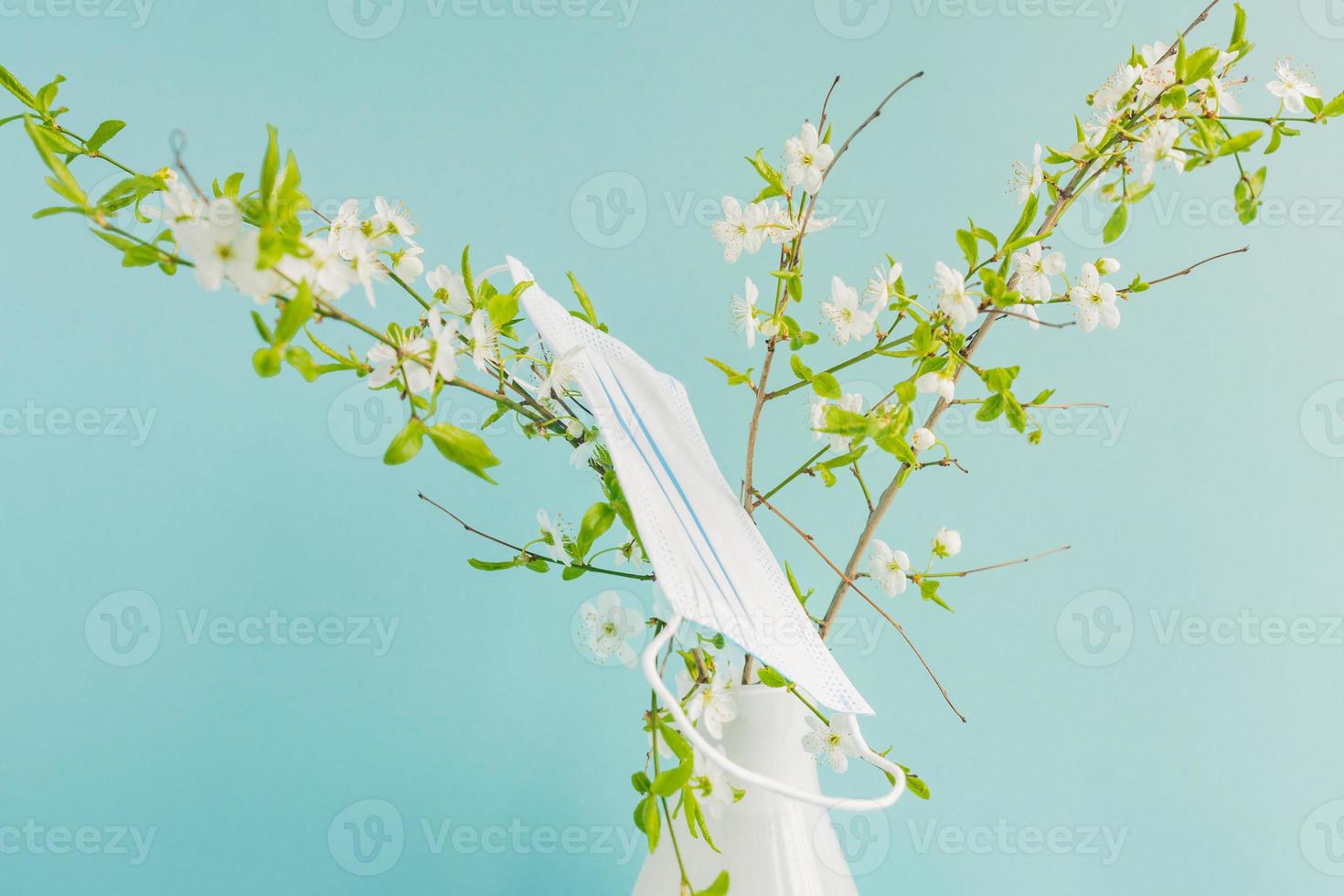 primavera fiorente ciliegia fiorire e medicina maschera su un' ramo. concetto di primavera fioritura allergia. foto