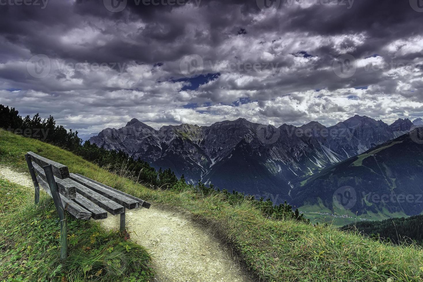 Visualizza di panchina con montagne su sfondo foto