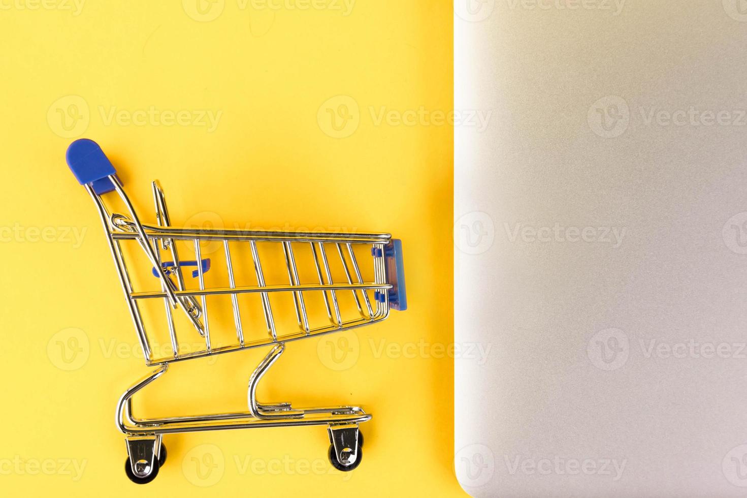 vuoto mini shopping carrello, shopping carrello, su un' giallo sfondo. rf richiesta per informazione. copia spazio foto