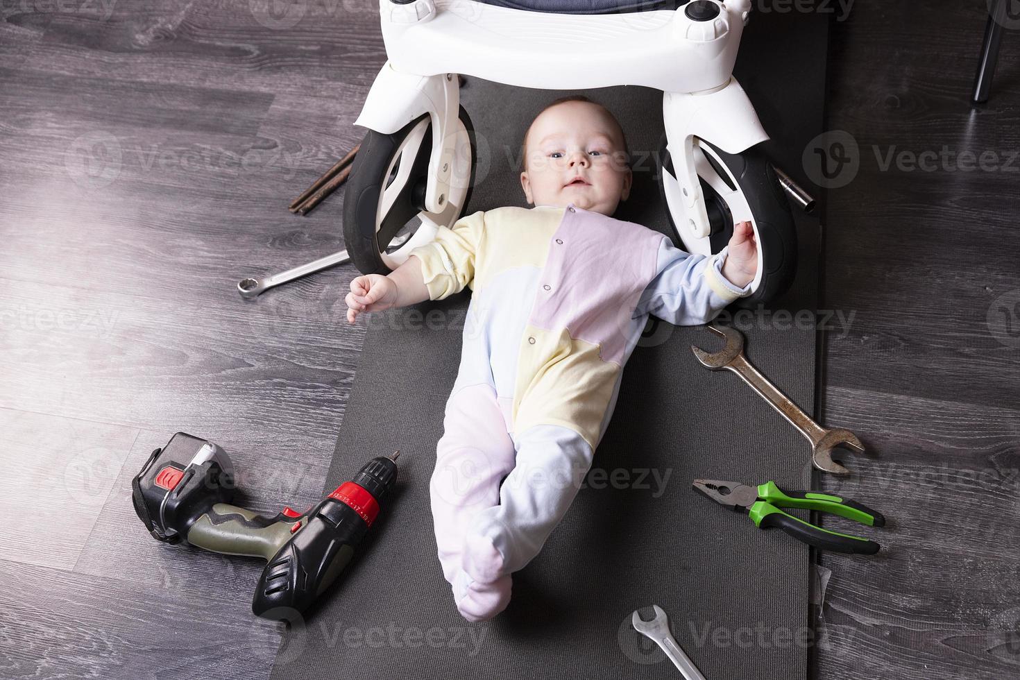 ragazzo meccanico riparazione il sospensione di un' bambino carrozza. noi riparazione qualunque cosa quello viaggi. umorismo, sfida. foto