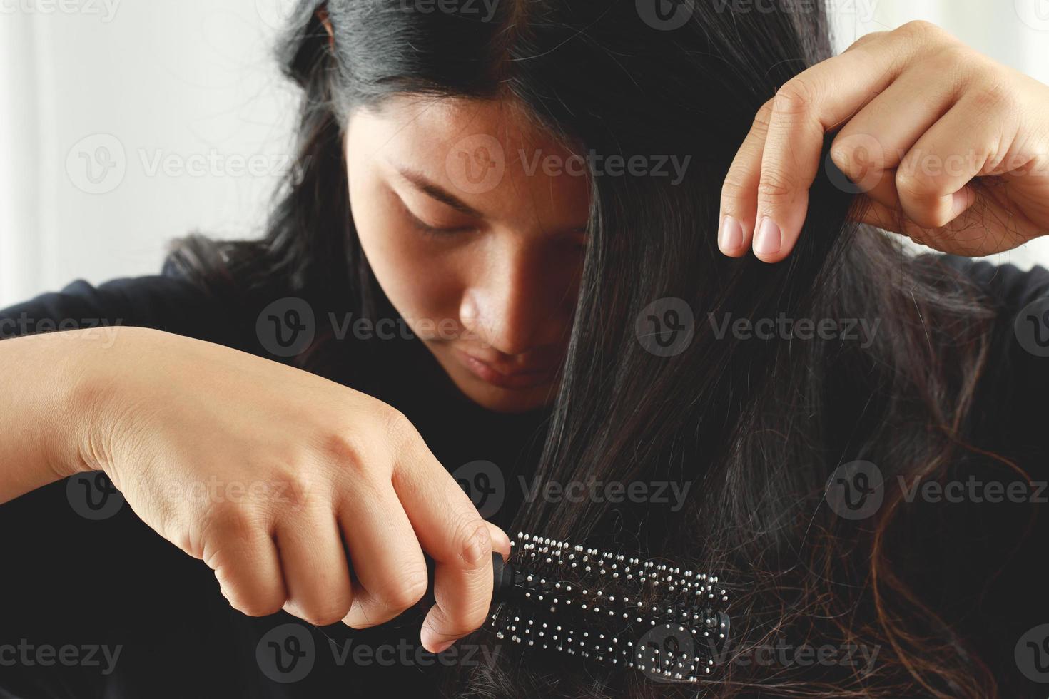 posteriore Visualizza giovane donna preoccupato di capelli perdita problema, ormonale squilibrio, fatica concetto. molti capelli autunno dopo pettinatura nel capelli spazzola nel mano. femmina districato sua capelli con un' pettine, Salute cura foto