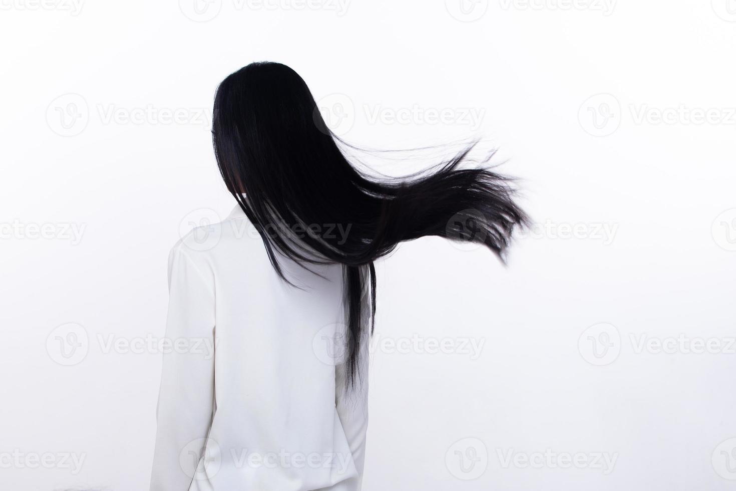 nero dritto lungo nero capelli donna gettare volare nel aria con moda elegante e divertimento la gioia. femmina girare indietro indossare bianca camicia esprimere emozione contento di soffio vento capelli, isolato bianca sfondo foto