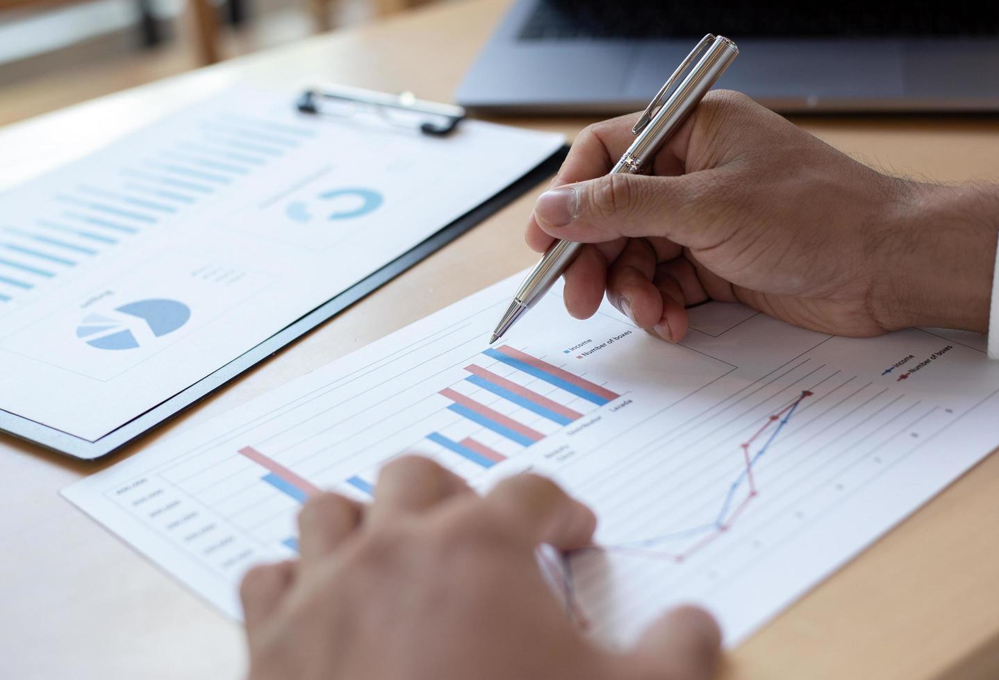 uomo d'affari che studia diagramma finanziario allo scrittorio del lavoro foto