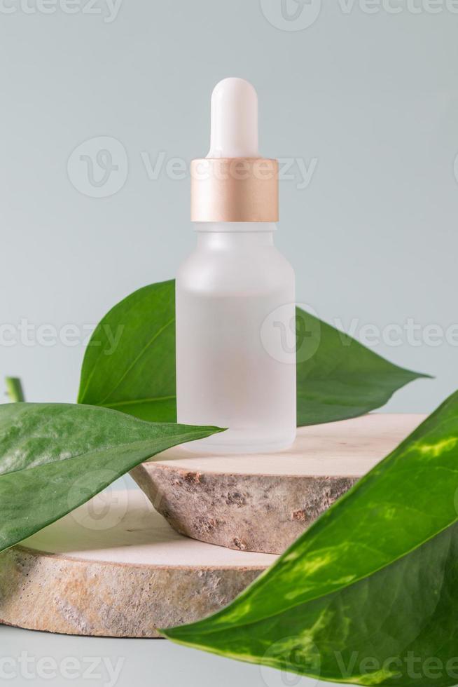 viso siero nel un' bicchiere pacchetto, bottiglia su un' grigio sfondo. trattamento per pelle con oli, vitamine e collagene. confezione di cosmetico bellezza Prodotto, copia spazio. foto