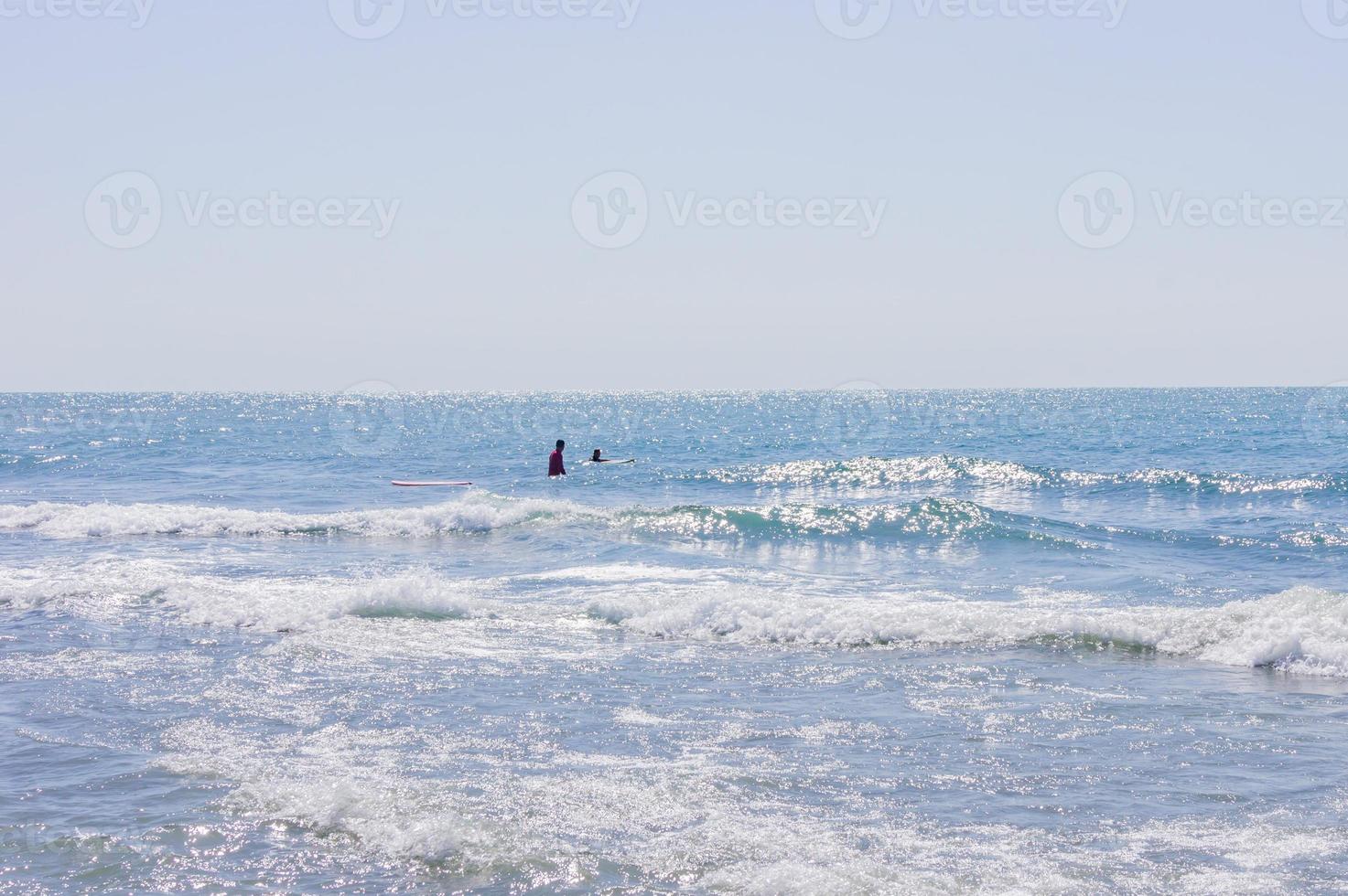 persone fare surf nel il oean nel un' soleggiato giorno foto