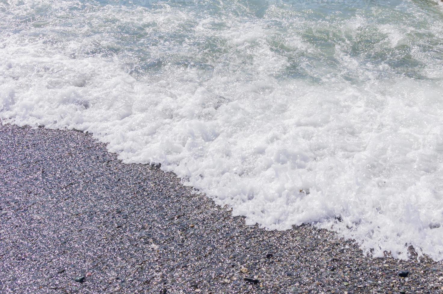 costa di ciottoli. mare con acqua trasparente e piccoli sassi foto