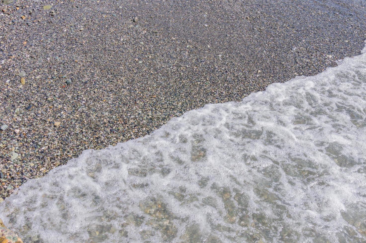 costa di ciottoli. mare con acqua trasparente e piccoli sassi foto