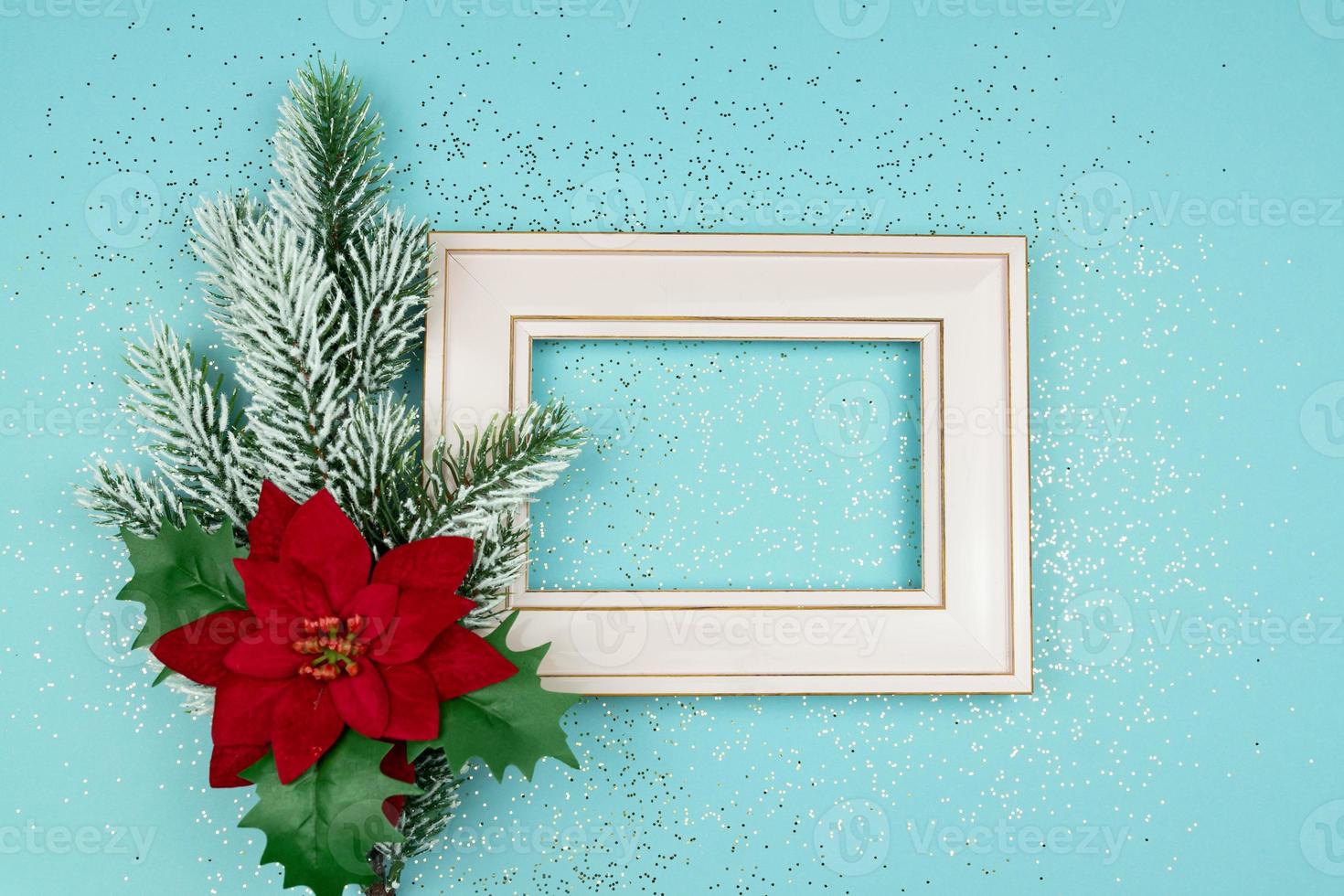 festivo saluto carta per Natale con foto telaio, abete rosso albero ramo e poinsettia su blu coriandoli sfondo.
