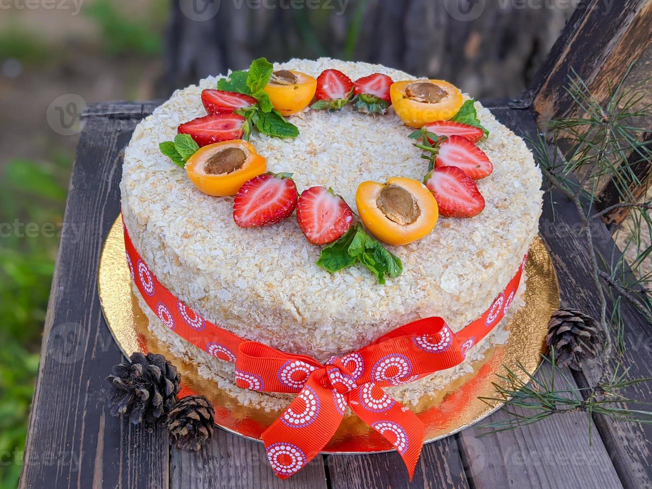 fatti in casa strato torta Napoleone decorato con fragola e metà di albicocca su di legno rustico sfondo foto