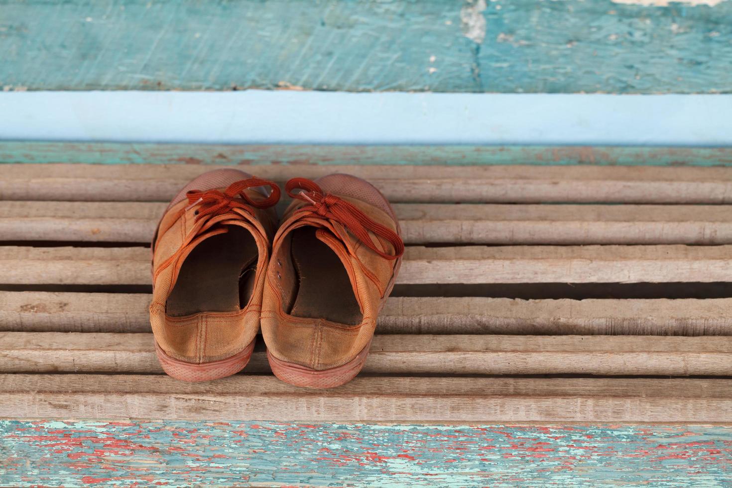 vecchio bambini scarpe da ginnastica un' di legno sfondo foto