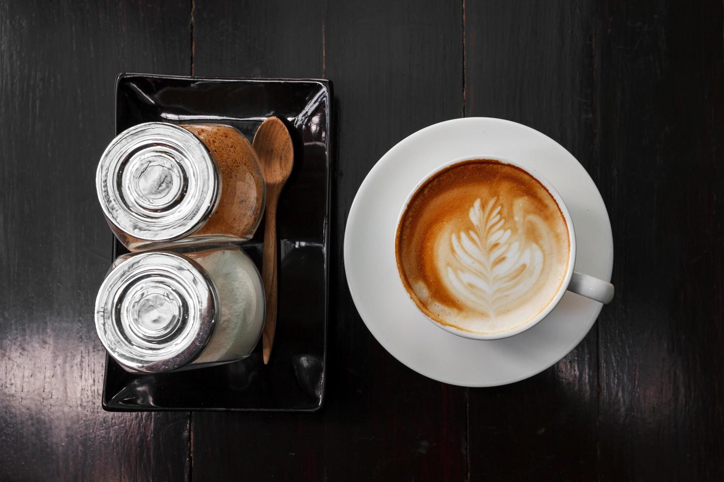 tazza di latte macchiato caffè e zucchero su di legno foto