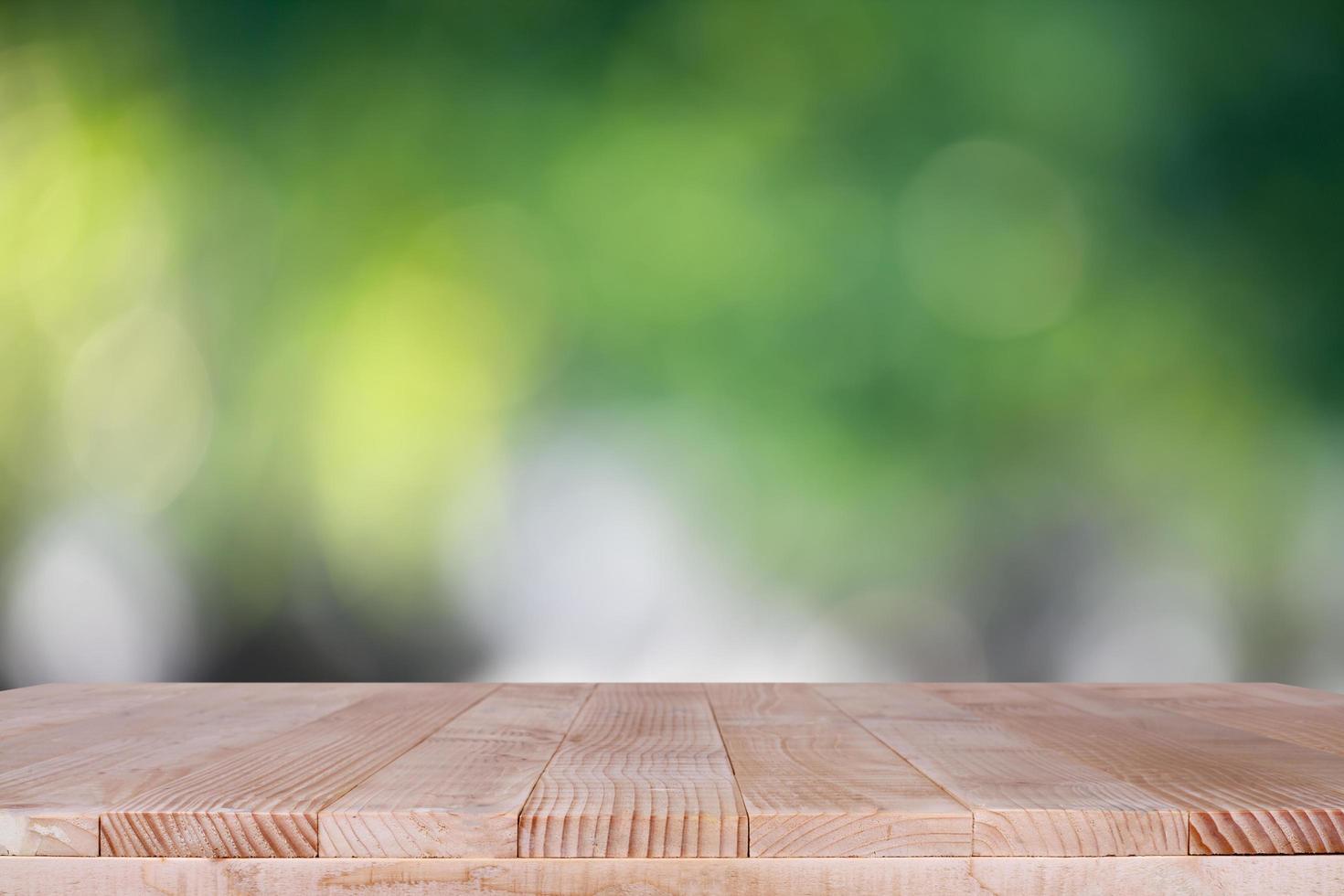 piano del tavolo in legno su sfondo verde bokeh - può essere utilizzato per il montaggio o visualizzare i tuoi prodotti foto