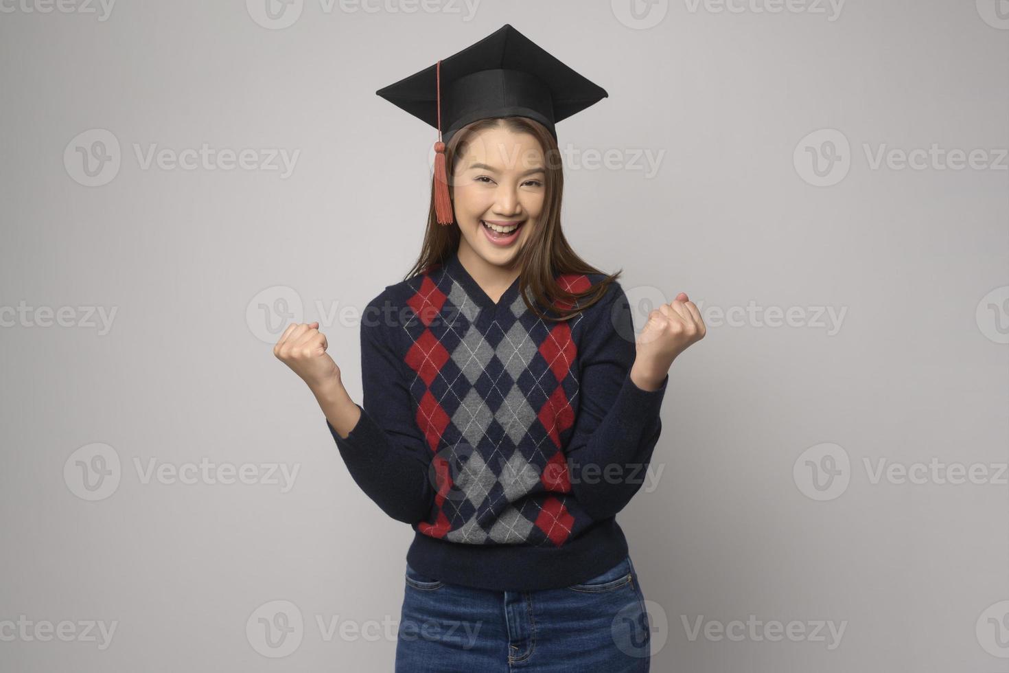giovane sorridente donna Tenere la laurea cappello, formazione scolastica e Università concetto foto