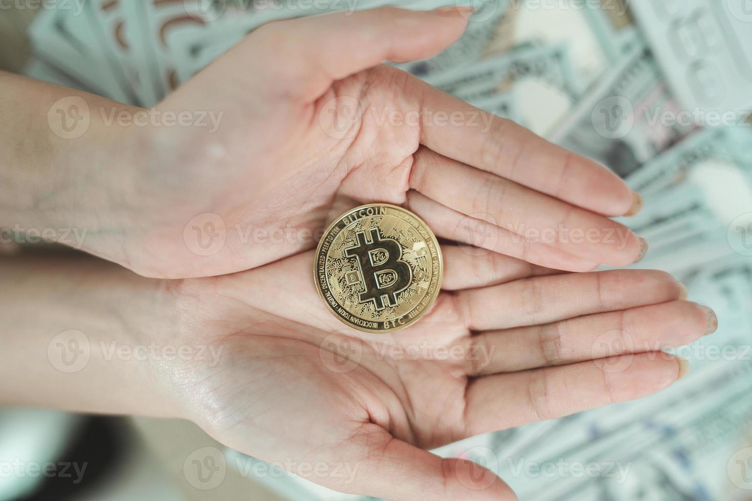 vicino su di mano donna Tenere oro bitcoin crypto moneta blockchain su dollaro conto sfondo su tavolo. crypto moneta blockchain Salvataggio investimento ricchezza concetto. foto