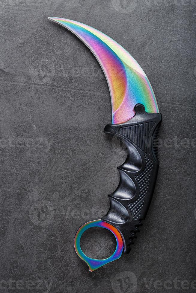 un' pugnale con un' acciaio lama con un' pendenza colore su un' nero sfondo. foto