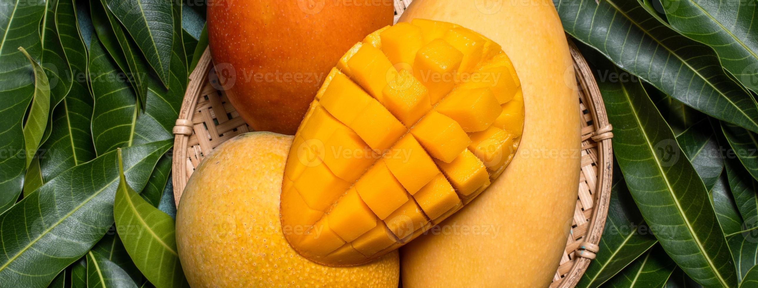 Mango, tropicale frutta, nel un' bambù di legno setaccio cestino su verde foglia sfondo, superiore Visualizza, pieno telaio, Bellissima, maturo raccogliere design concetto. foto