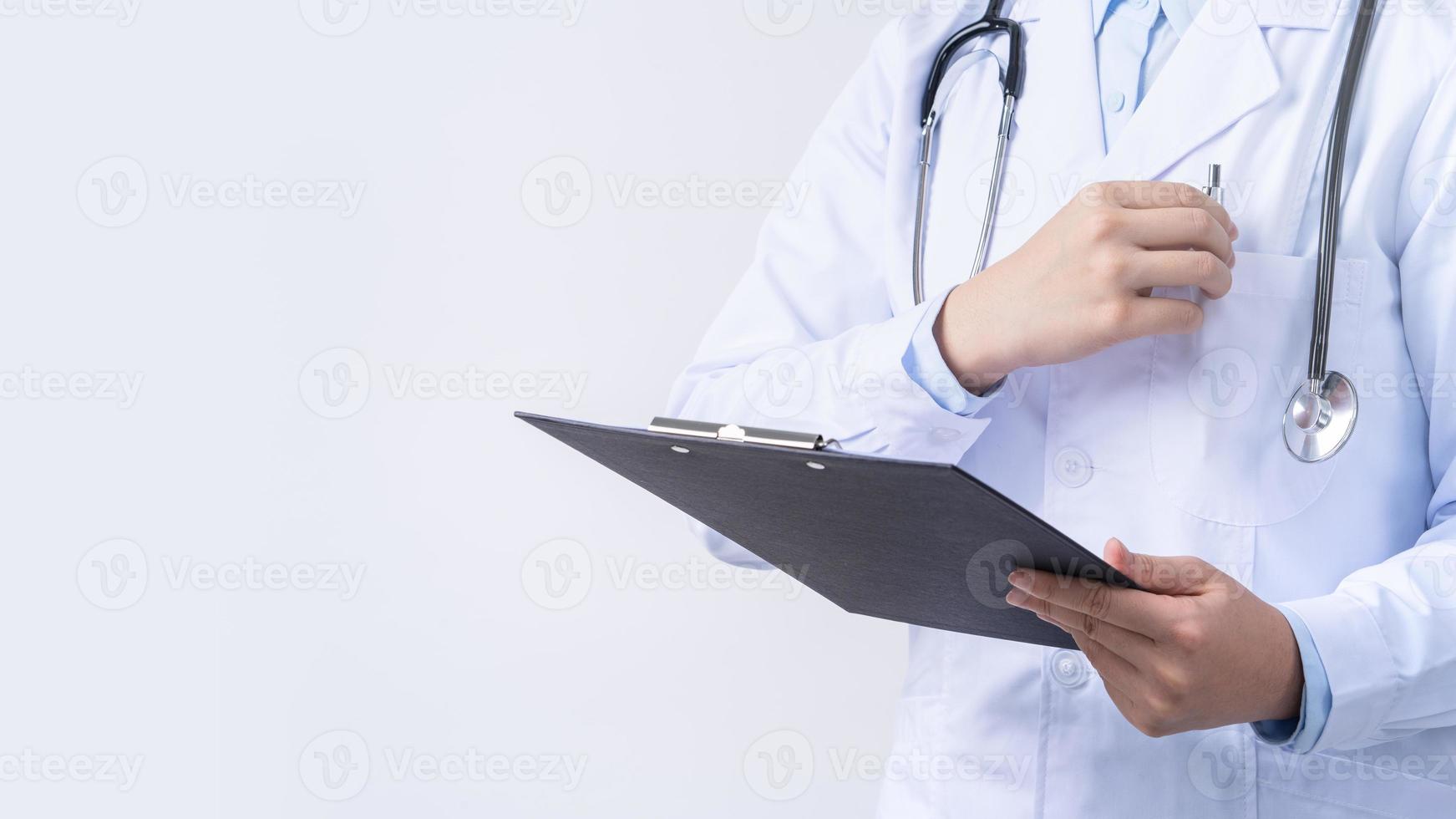 medico con stetoscopio nel bianca cappotto Tenere appunti, scrittura medico disco diagnosi, isolato su bianca sfondo, vicino su, ritagliata Visualizza. foto