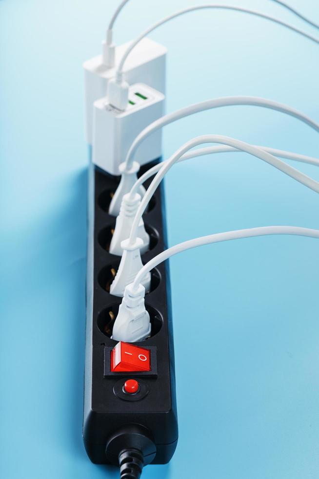 elettrico alimentazione filtro con inserito bianca spine di elettrico elettrodomestici su un' blu sfondo. foto