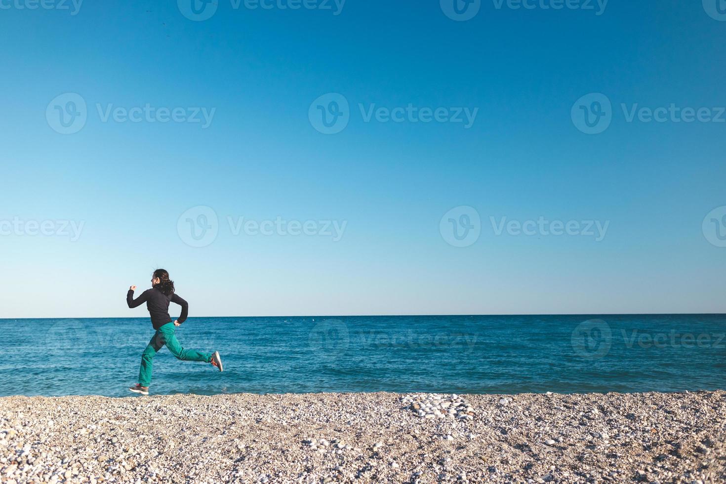 una ragazza in una corsa mattutina sulla spiaggia foto