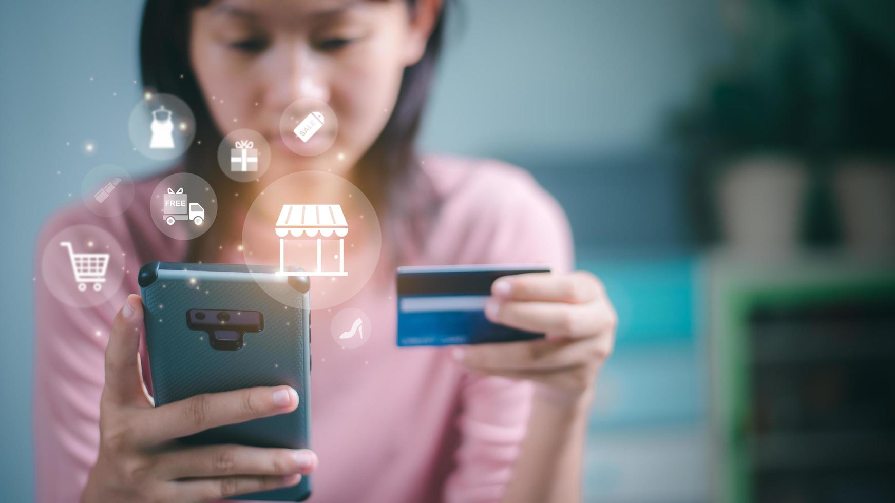 un' donna usi un' credito carta per finanziario transazioni su sua smartphone. pagamento concetto con senza fili comunicazione tecnologia, shopping servizio su il in linea ragnatela e offerte casa consegna. foto