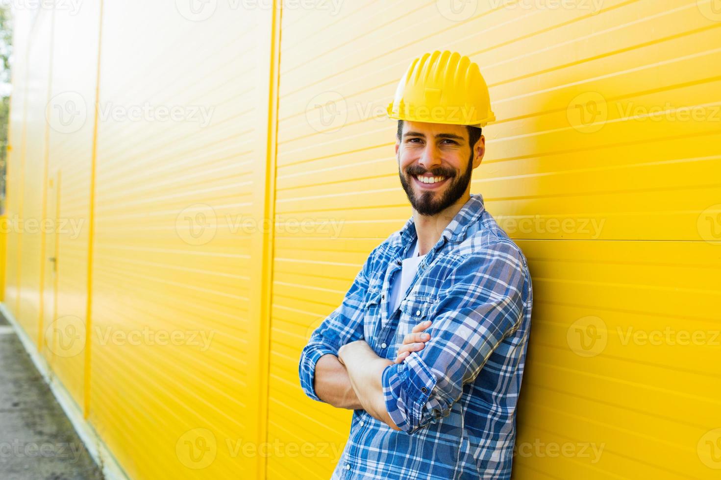 lavoratore adulto con casco sul muro giallo foto