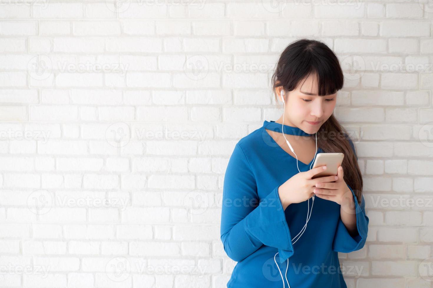 bello ritratto asiatico giovane donna in piedi felice divertirsi e divertirsi ascolta musica con le cuffie su cemento cemento sfondo, stile di vita della ragazza rilassarsi radio sonora con auricolare, concetto di tecnologia. foto