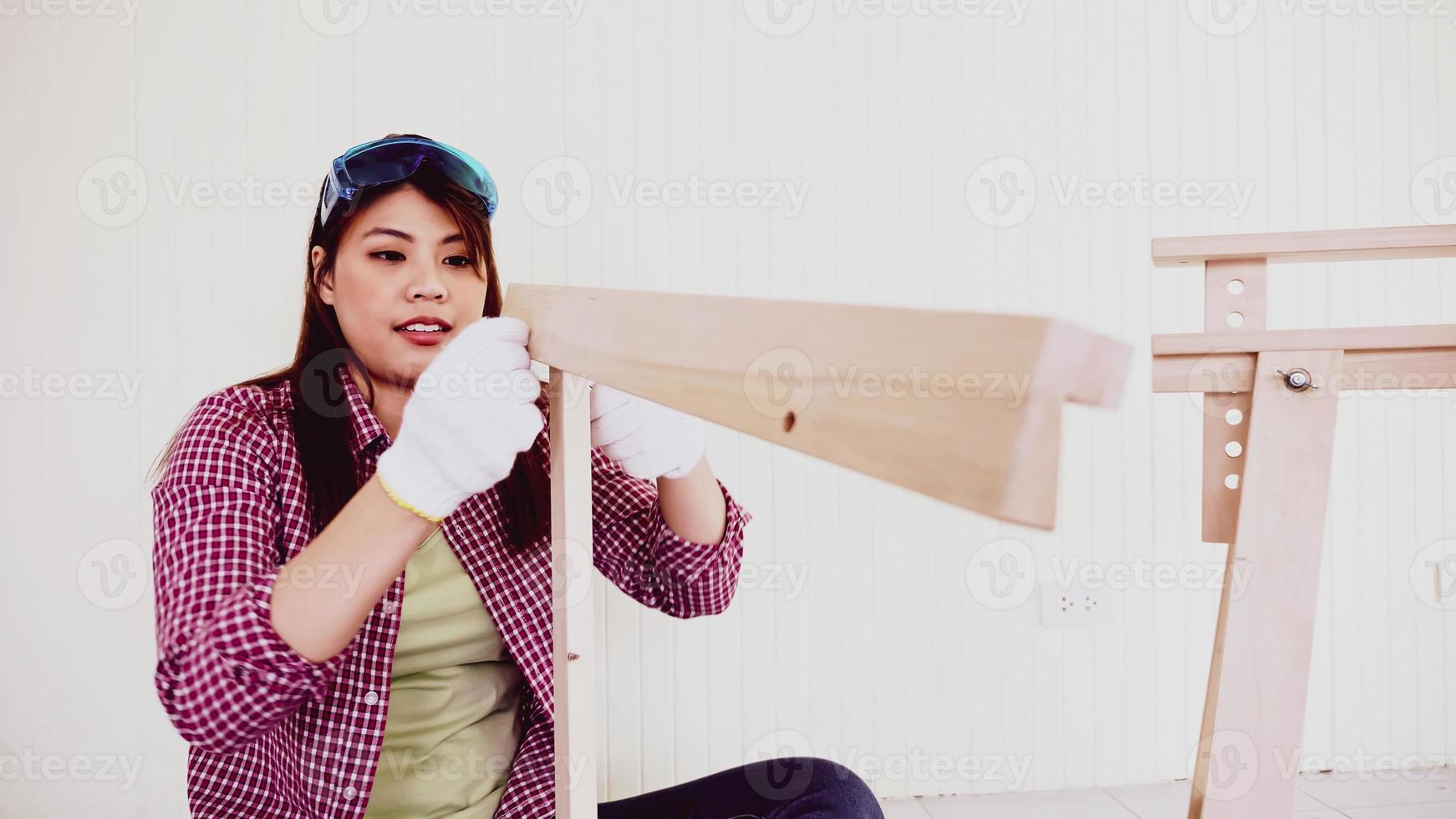 femmina falegname adattamento pezzi di tavole insieme a luogo. foto