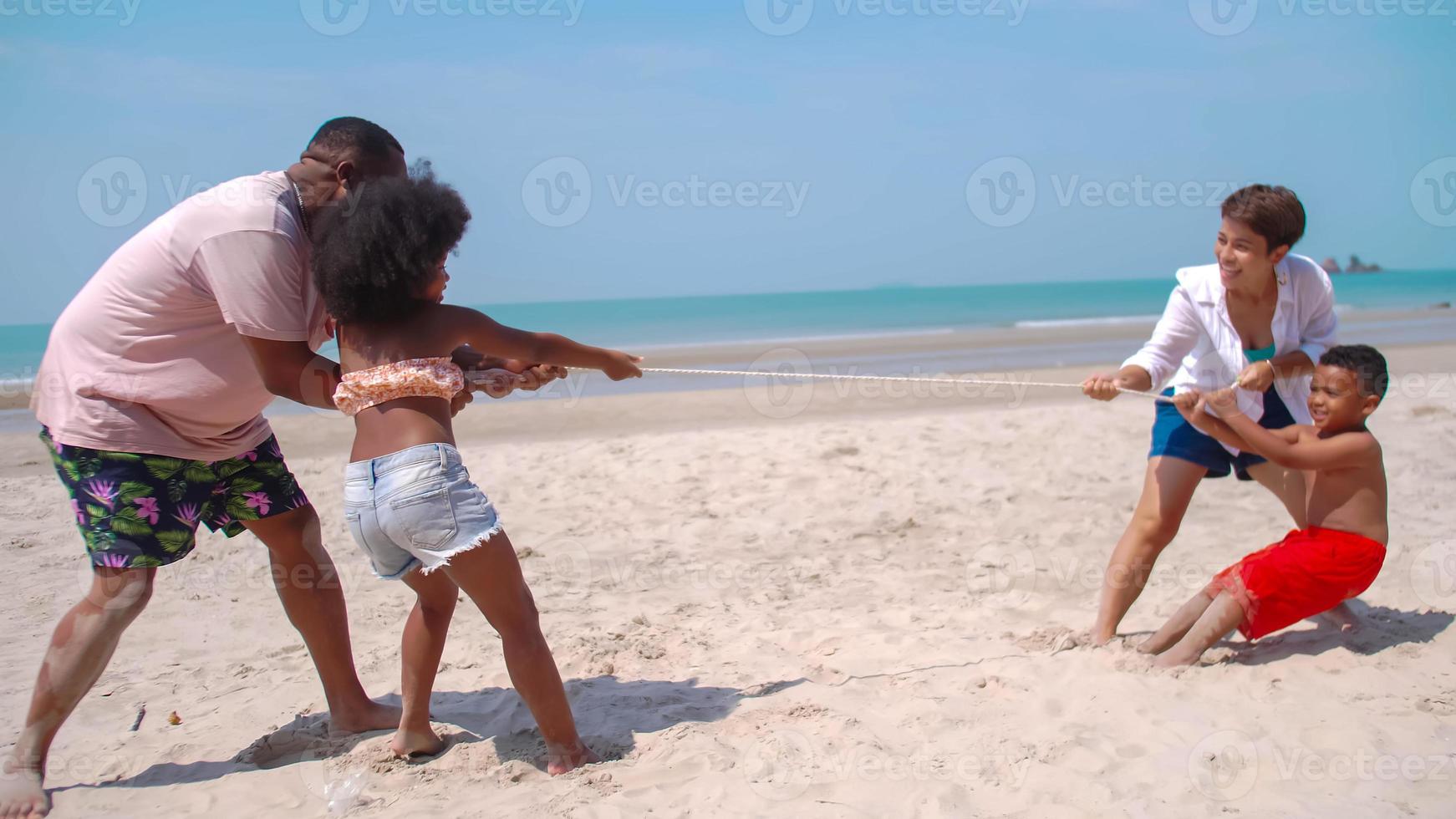 famiglia avendo divertimento giocando insieme su il spiaggia. foto