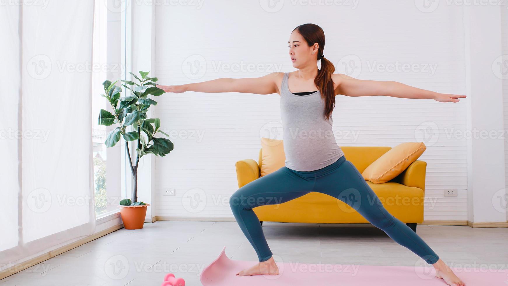 bellissimo giovane asiatico incinta donna nel abbigliamento sportivo è fare yoga a casa. foto