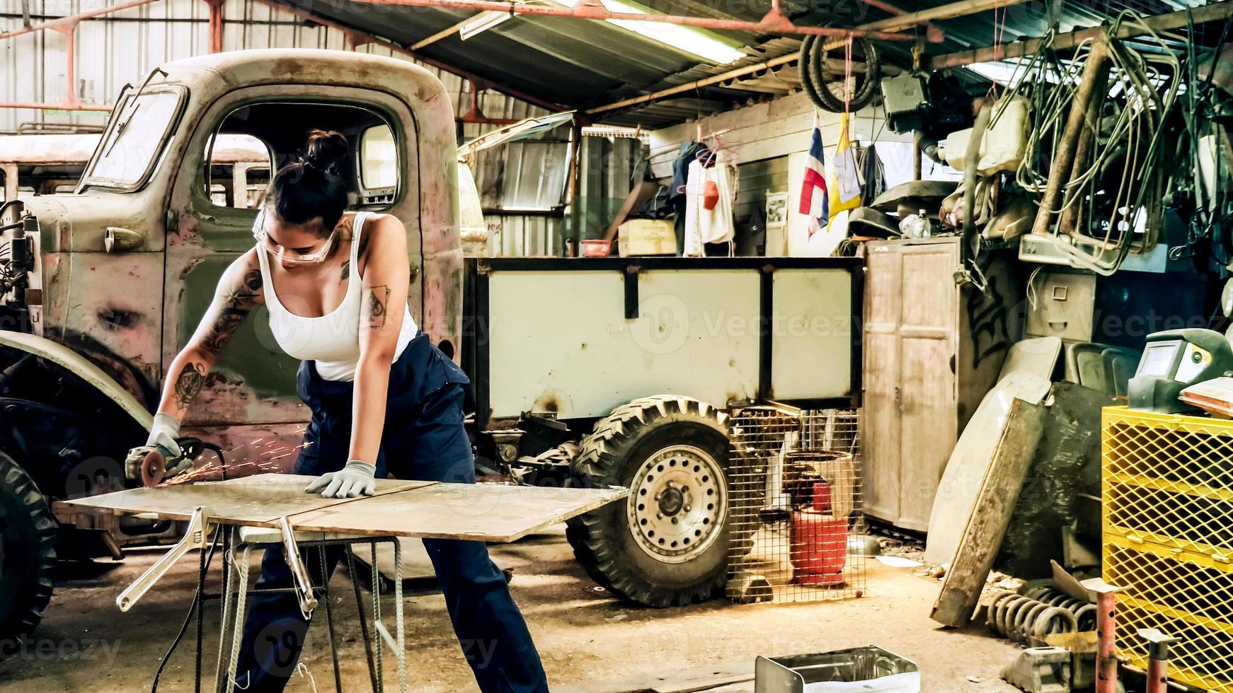 attraente giovane donna meccanico lavoratore riparazione un' Vintage ▾ auto nel vecchio box auto. foto