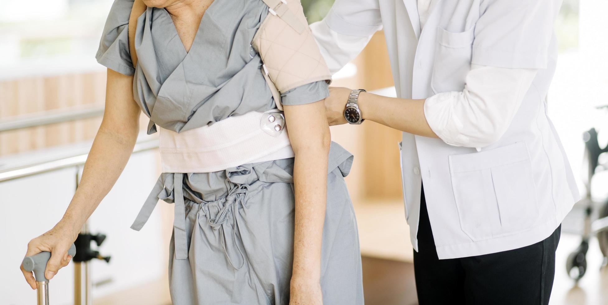 fisioterapista porzione anziano donna con camminatore a riparatore ginnastica foto