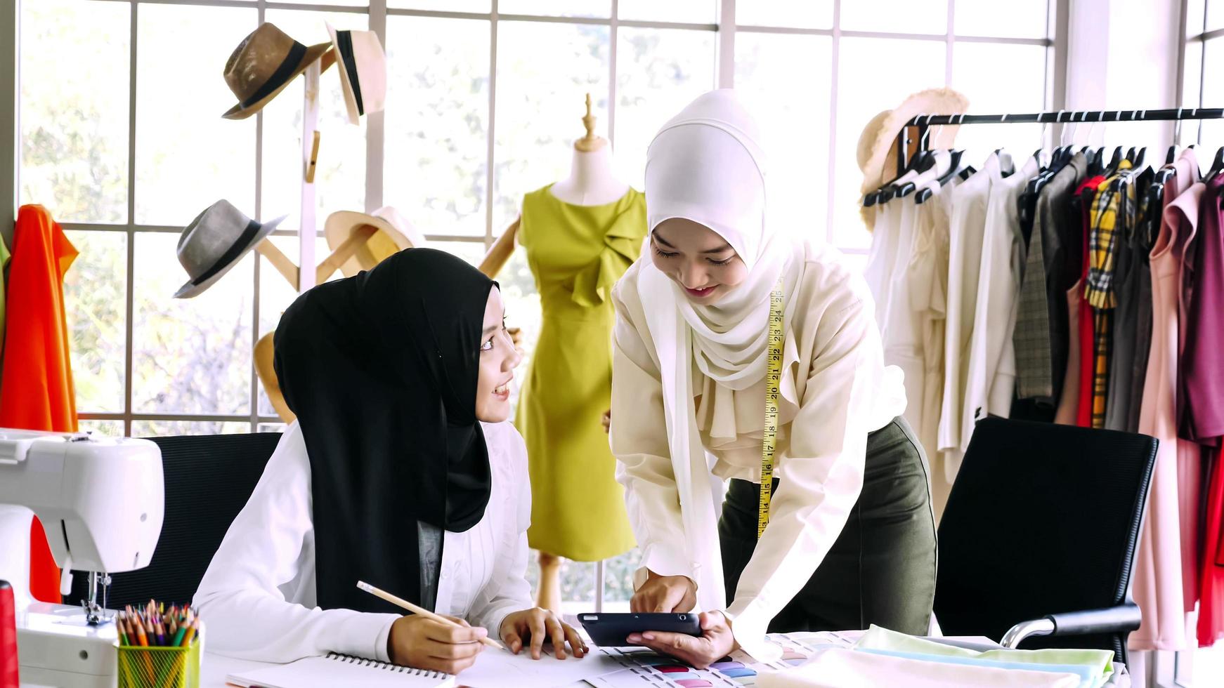 bellissimo musulmano donne Lavorando insieme a il capi di abbigliamento ufficio. foto