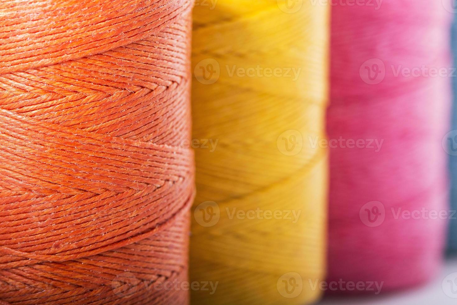 rocchetti di filo in giallo, arancione e rosa foto