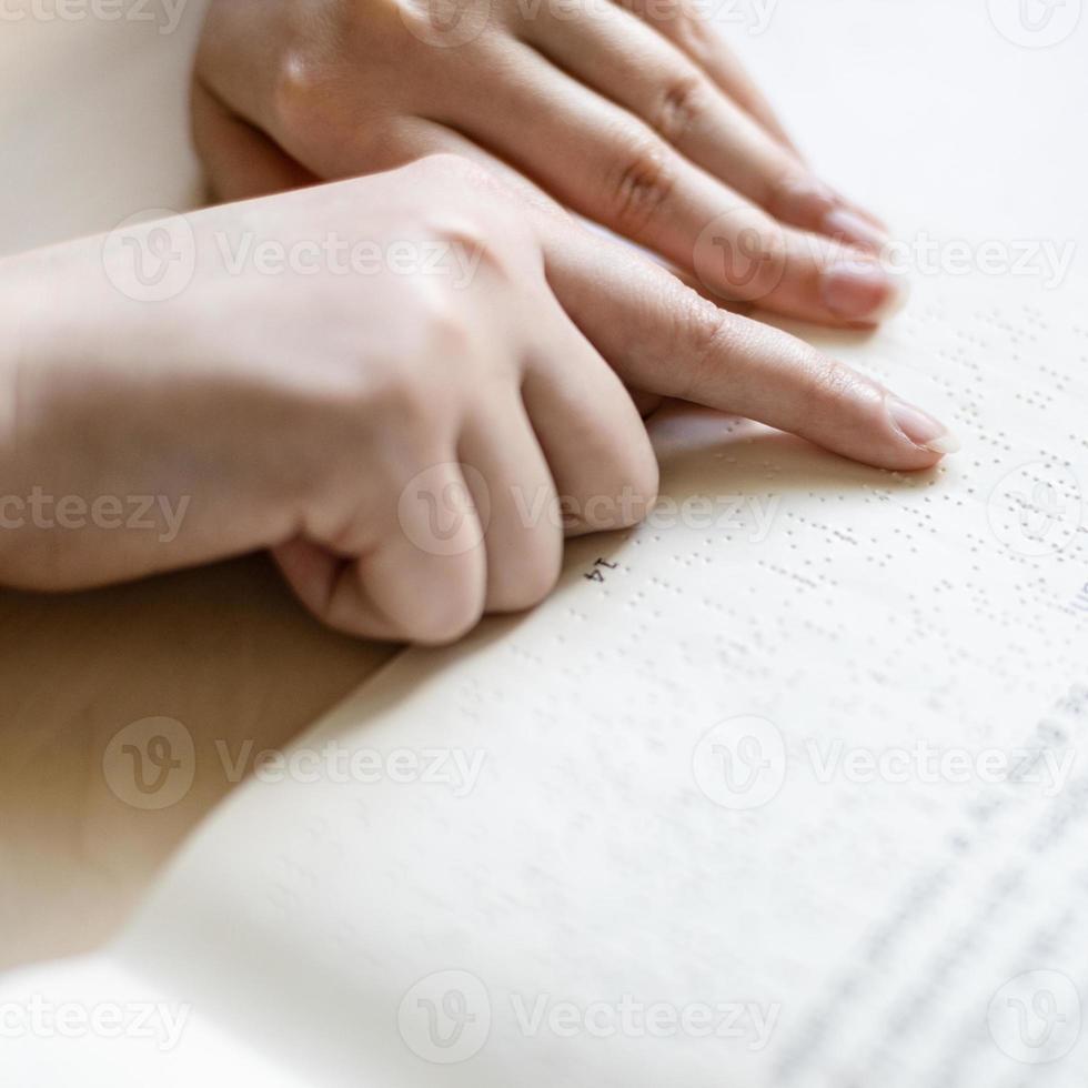 lettura libro con braille e solito testo foto