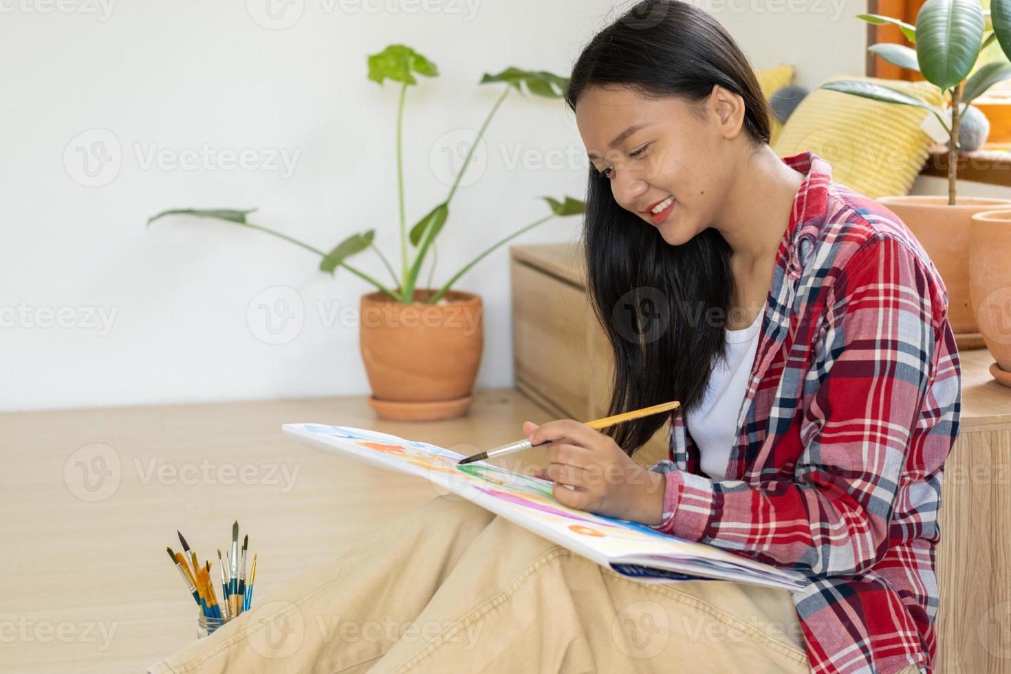 giovane ragazza seduta su il pavimento e pittura su carta a casa. passatempo e arte studia a casa. foto