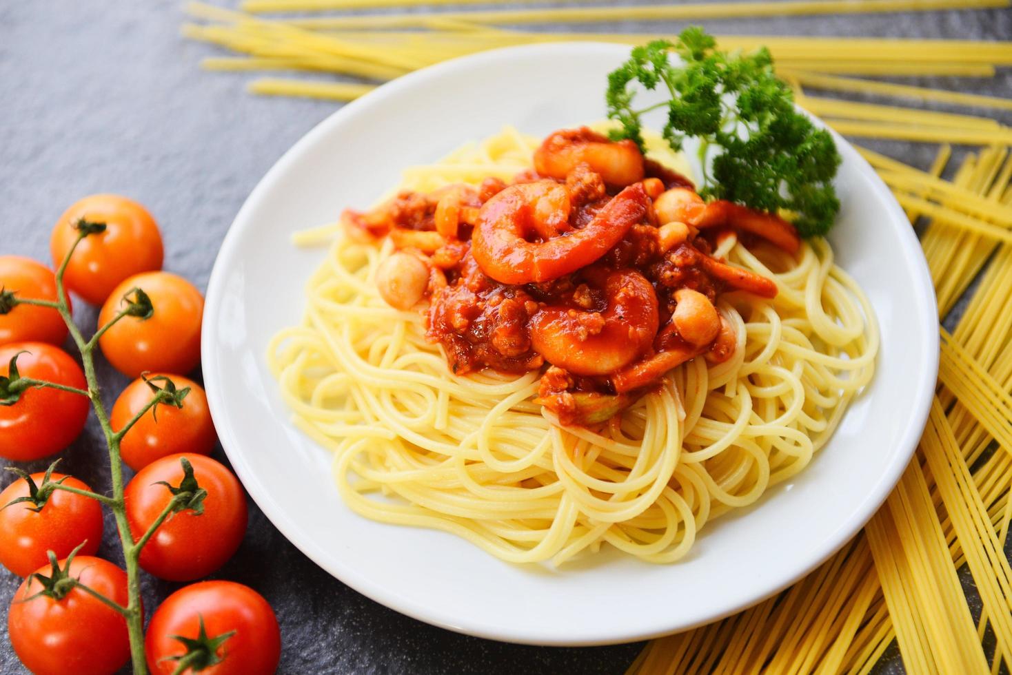 spaghetti bolognese italiano pasta con gamberetto gamberetto servito su bianca piatto con pomodoro prezzemolo nel il ristorante italiano cibo e menù foto