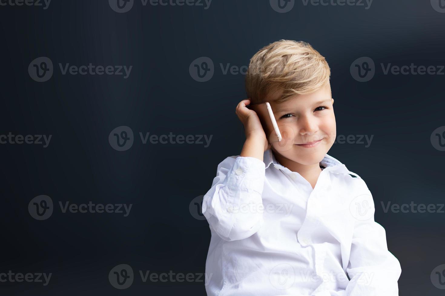 carino ragazzo parlando su cellula Telefono. foto