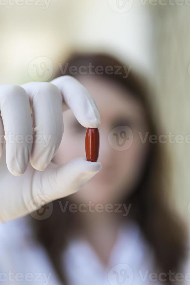 medico che tiene la capsula pillola rossa foto