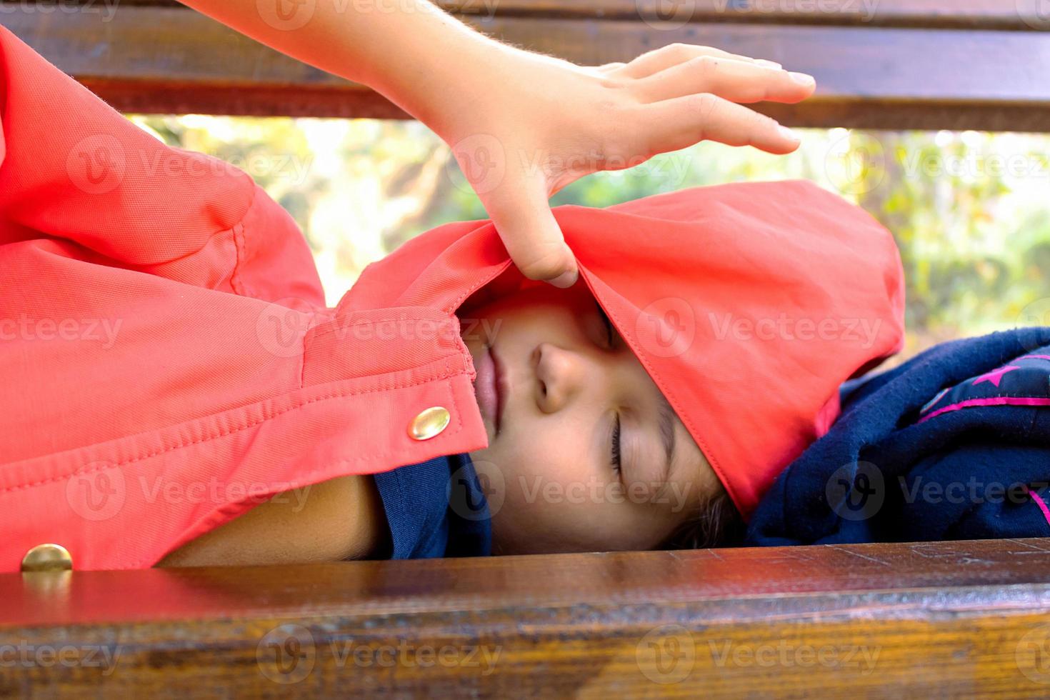 piccolo ragazza napping su un' panchina a il parco. foto