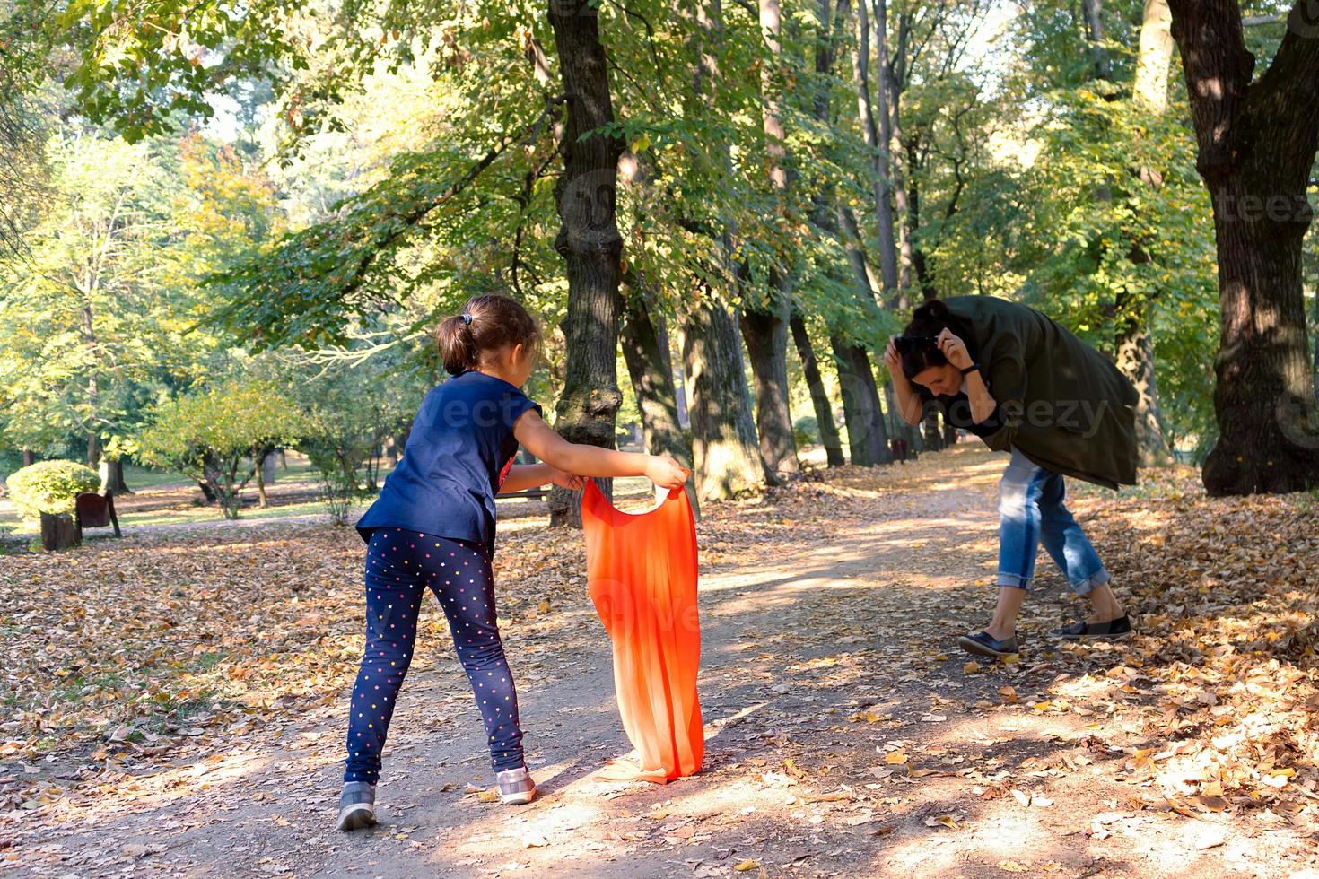 piccolo ragazza avendo divertimento mentre giocando con sua madre nel natura. foto