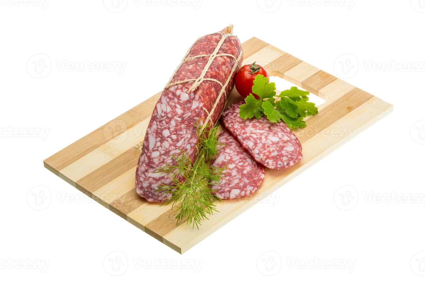 salame su di legno tavola e bianca sfondo foto