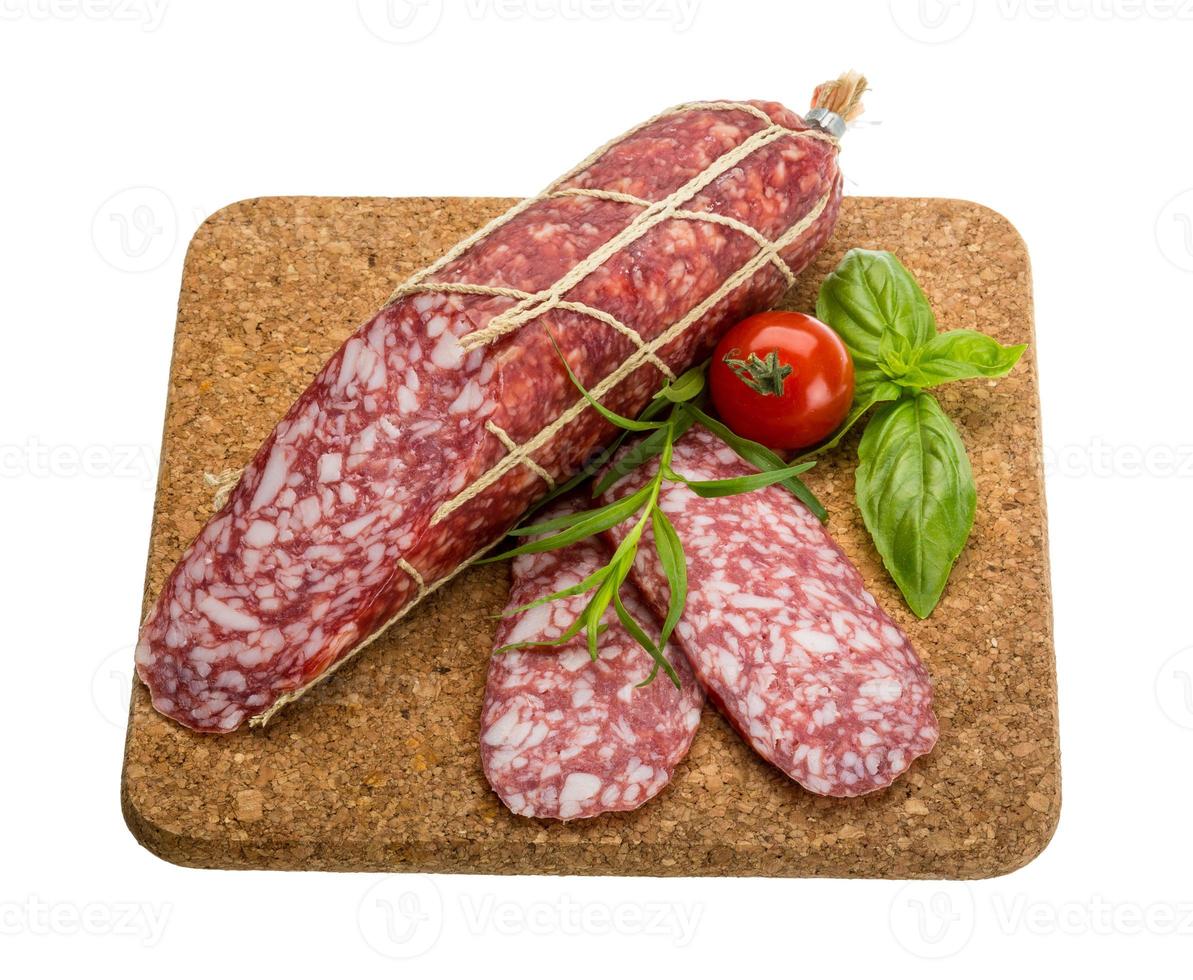 salame su di legno tavola e bianca sfondo foto