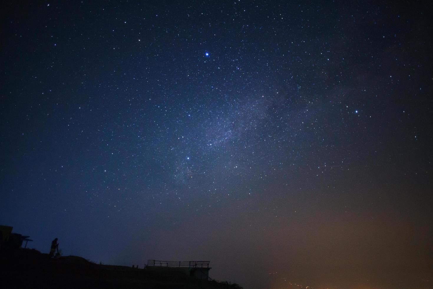 silhouette di un' in piedi uomo con telescopio o telecamera Guardando il svelto modo galassia foto