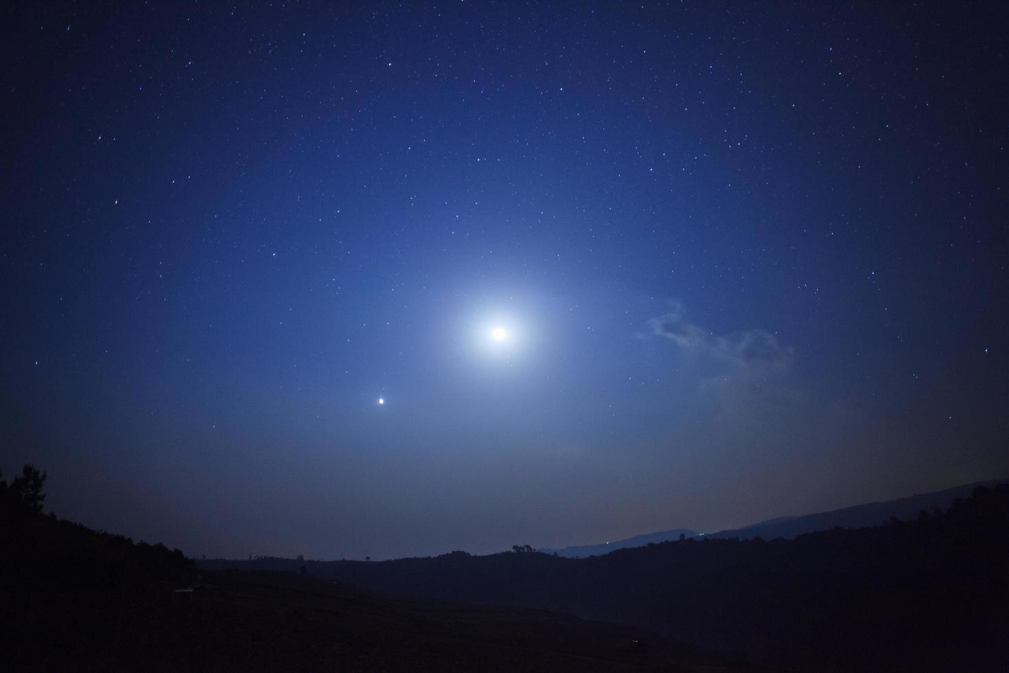 notte natura sfondo, nuvoloso cielo con stelle e Luna leggero foto