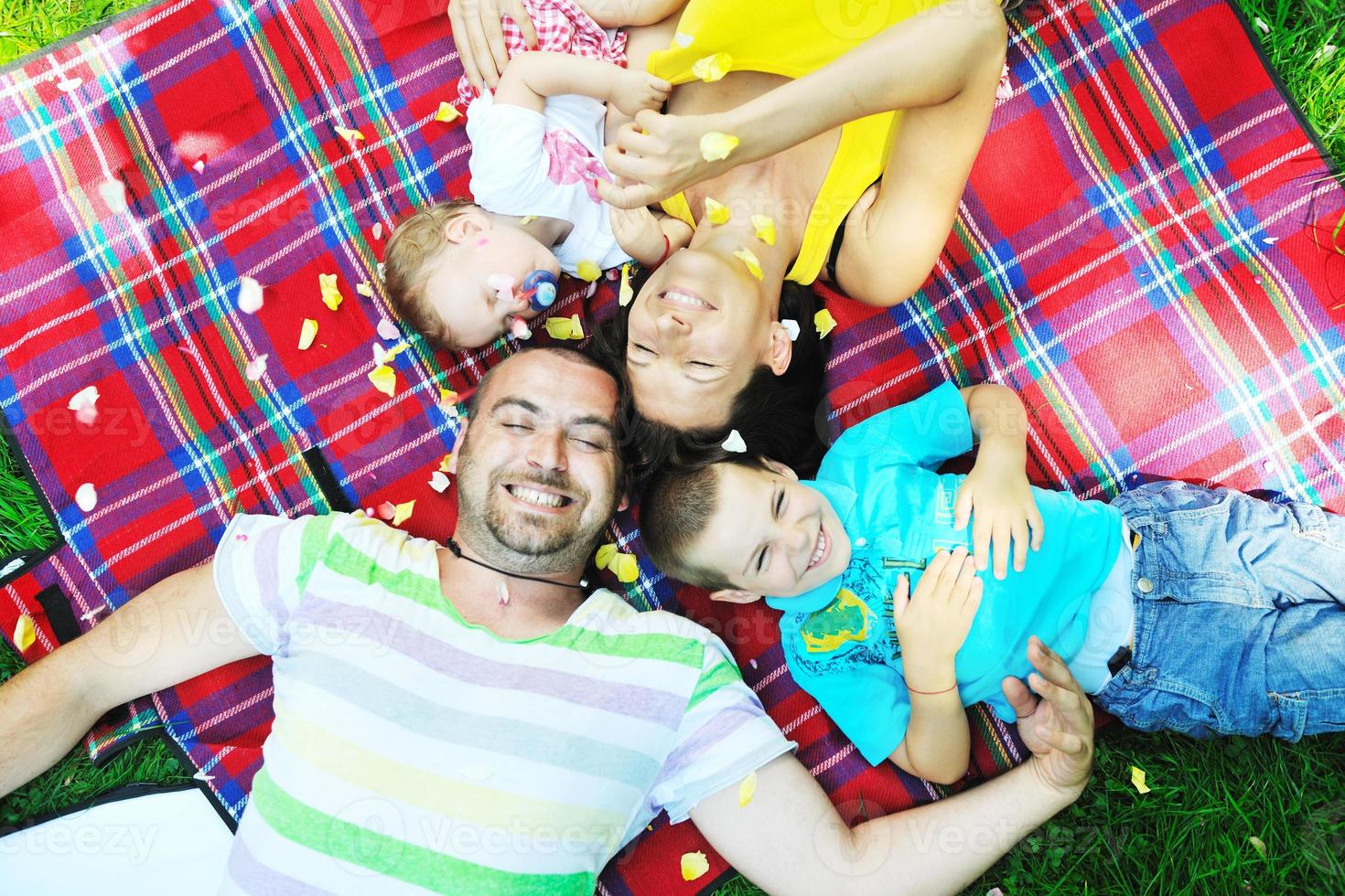 felice giovane coppia con i loro bambini si divertono al parco foto