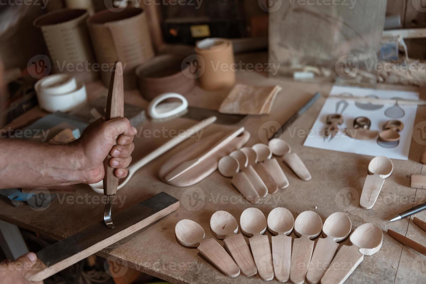 mani intaglio cucchiaio a partire dal Di legno, Lavorando con scalpello vicino su. di legno officina. processi di fabbricazione di legno cucchiaio foto