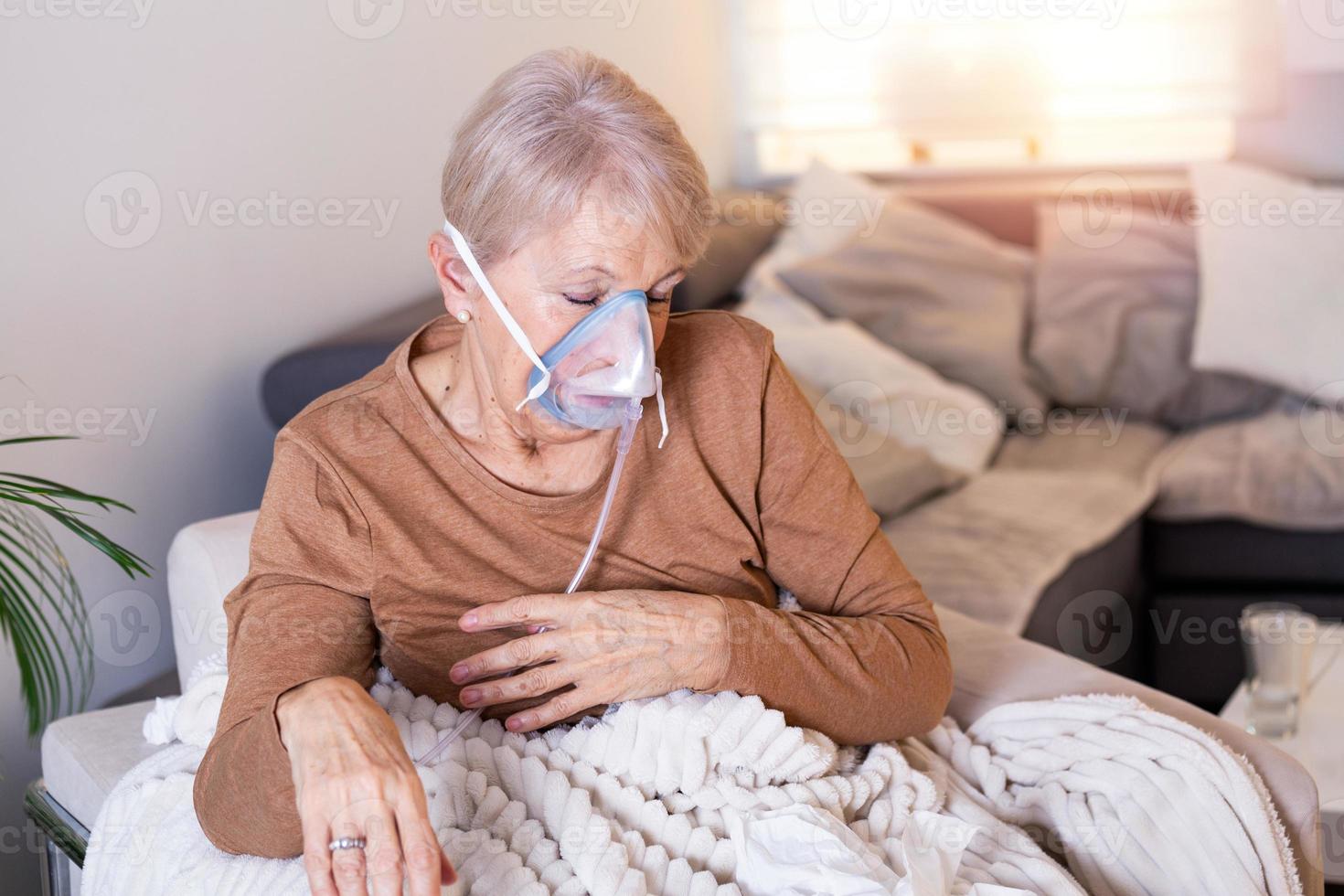 malato anziano donna fabbricazione inalazione, medicina è il migliore medicinale. malato anziano donna indossare un ossigeno maschera e in corso trattamento. anziano donna con un inalatore foto